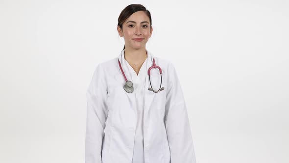 Female doctor folding arms against white background