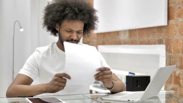 Upset African Man Reading Report in Shock By Loss