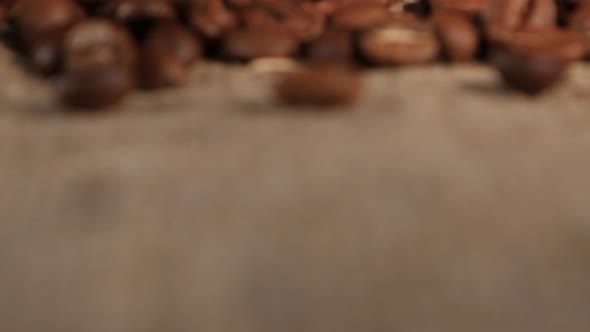 Fragrant Coffee Beans Lie on Brown Burlap on the Table