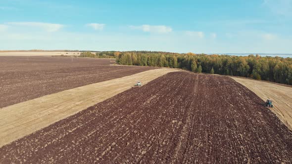 An Autumn Landscape of Fields and Blue Sky - Tractors Plows the Field