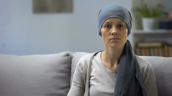 Woman After Chemotherapy Sitting at Home and Looking Into Camera, Background