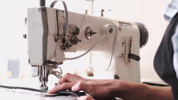 The Craftsman Stitches a Men's Leather Belt on a Sewing Machine