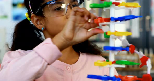 Schoolkid experimenting molecule model in laboratory 4k