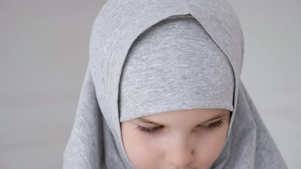 Young Muslim Teen Girl in Hijab Shyly Looking at Camera and Smiling