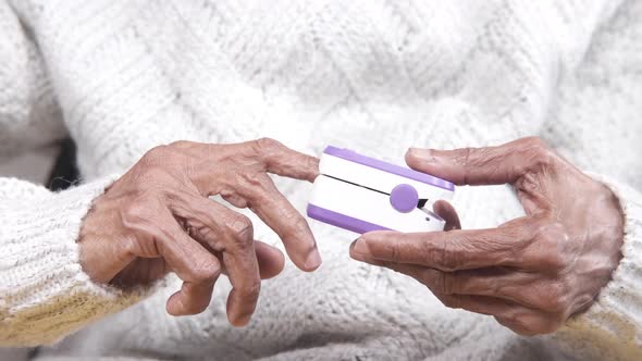 Elderly Women Hand Using Pulse Oximeter