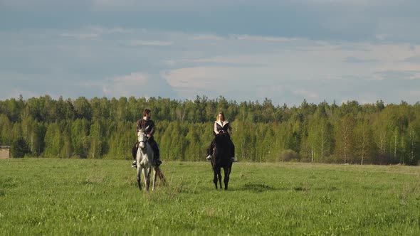 People are Riding Through a Forest Meadow