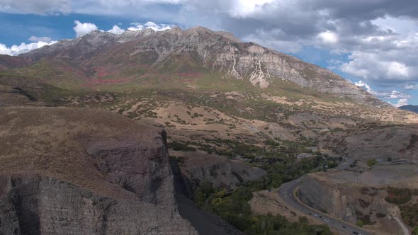 Aerial view of mountains and cars driving by on a road