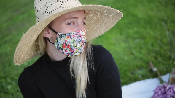 Fashionable girl wearing face mask flirting with camera at the park