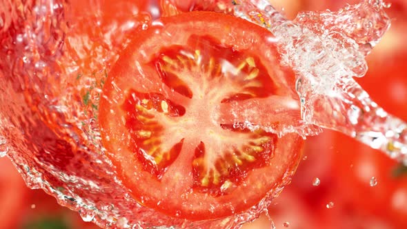 Super Slow Motion Shot of Splashing Water on Rotating Tomato Slice at 1000Fps