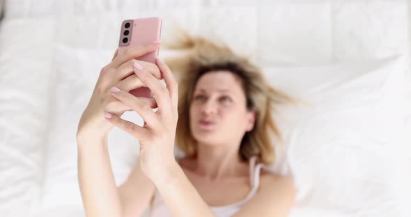 A Woman Lying on Her Back Takes a Selfie Shallow Focus