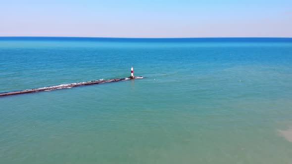 Aerial View Red Lighthouse By the Sea on a Sunny Day. View From a Quadcopter on a Red Lighthouse.