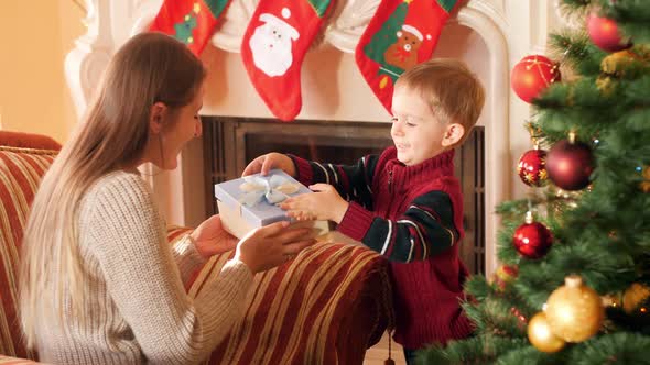 Footage of Little Boy Giving Present To His Mother on Christmas Morning, Family Giving