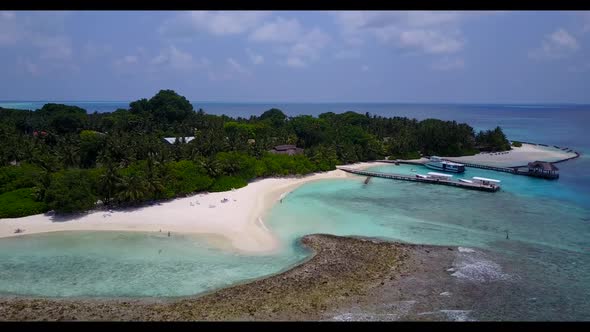 Aerial view scenery of idyllic coastline beach break by turquoise lagoon with white sandy background