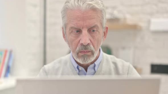 Close Up of Old Man Eyes Reading on Laptop