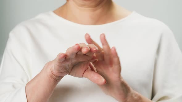 Old Woman Applying Hand Cream Closeup