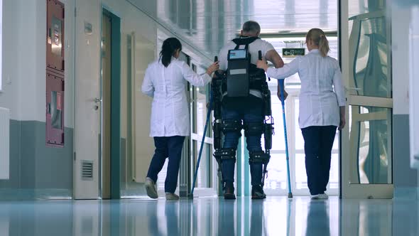 Doctors are Helping a Man to Walk in the Exoskeleton