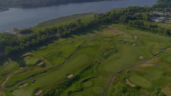 Aerial Tilt Down and Panning Around a Golf Course by the Water