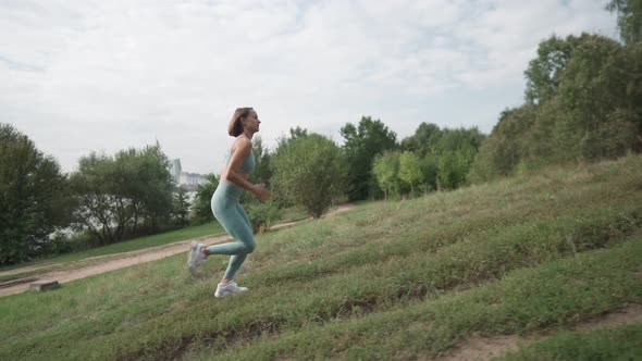 Slow Motion Shot Young Woman Running on the Hard Trail