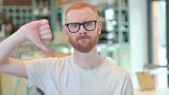 Portrait of Thumbs Down By Attractive Redhead Man