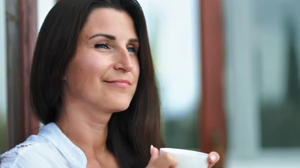 Happy Female Face Drinking Coffee or Tea Holding White Porcelain Cup By Hands Enjoying Weekend