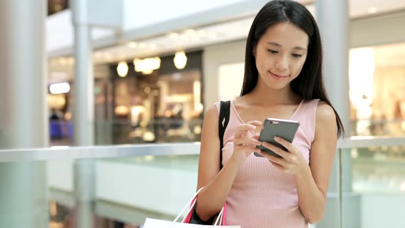 Woman use of mobile phone in shopping mall 