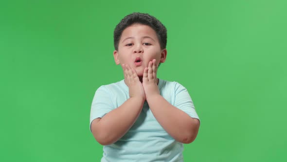 The Shocked Asian Little Boy Grabbing His Head While Saying Wow On Green Screen Background