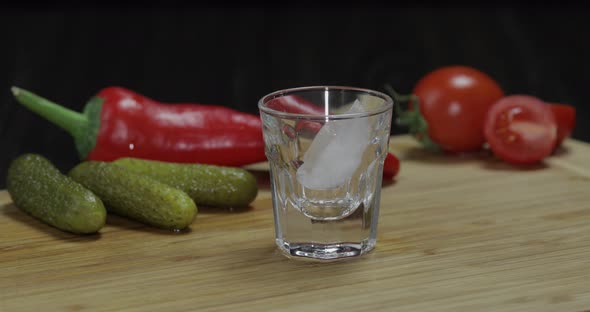 Man Puts a Glass Then Fills It with Vodka and Picks Up a Glass