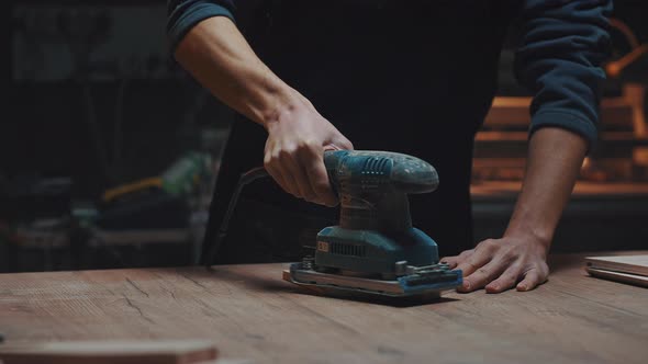 Close Portrait of a Carpenter with a Grinder in His Hands