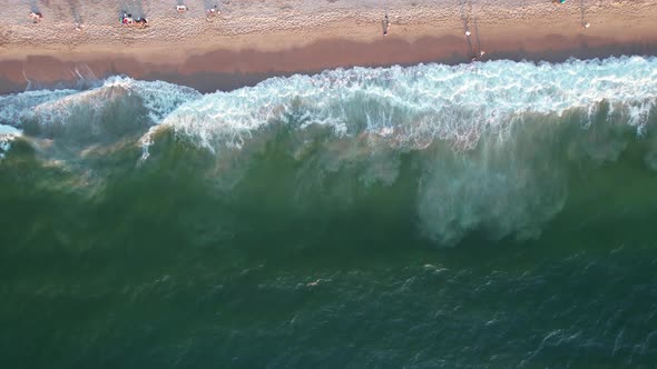 relaxing view of green ocean waves crashing on a Mexican beach in Puerto Vallarta at sunset, aerial