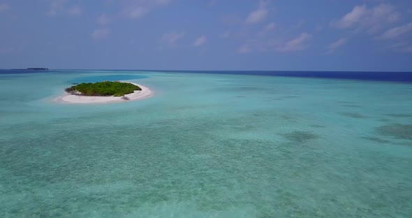 Tropical flying travel shot of a white sand paradise beach and blue sea background in hi res 4K