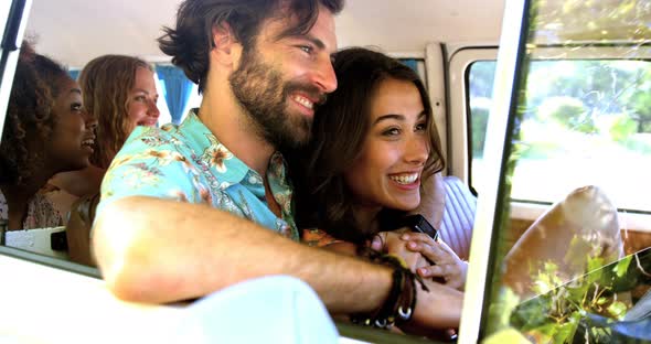 Hipster friends talking inside of a van