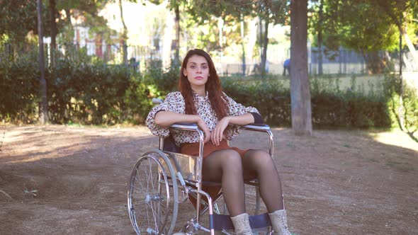 living with disabilities - thoughtful woman with paraplegia alone in the park