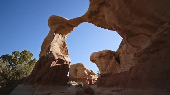 Hiking through and looking up at sandstone arch in the desert