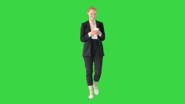 Beautiful Young Blond Business Woman Walking Holding a Cup of Coffee on a Green Screen Chroma Key