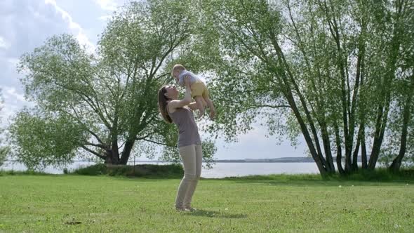 Happy Mother Lifting Baby in Air alt