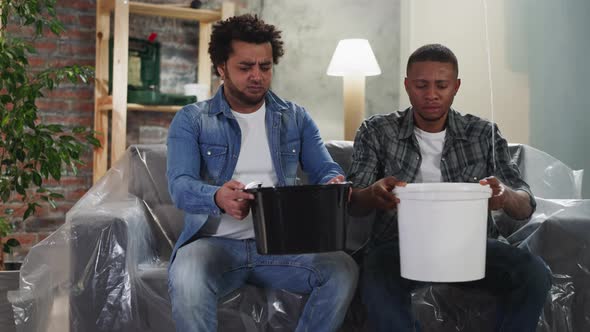 AfricanAmerican Guys Collect Leaking Water Into Basins