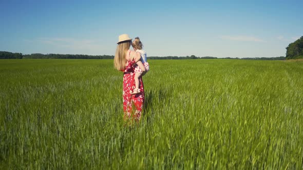 Cam Tracking: Mom, Wearing Summer Hat and Dress, Sunglasses, Walks Across an Endless Field