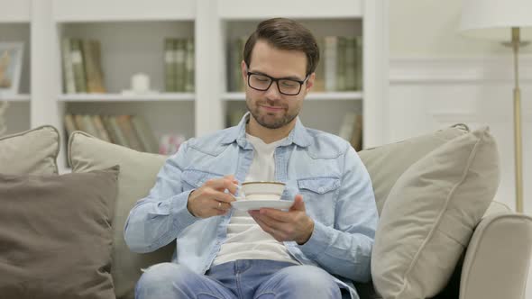 Relaxed Young Man Drinking Tea at Home