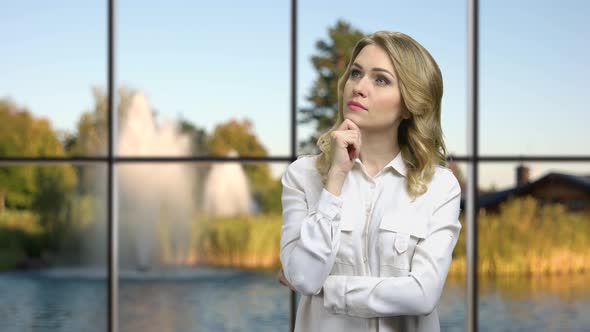 Young Pensive Woman Holding Hand Under Chin.