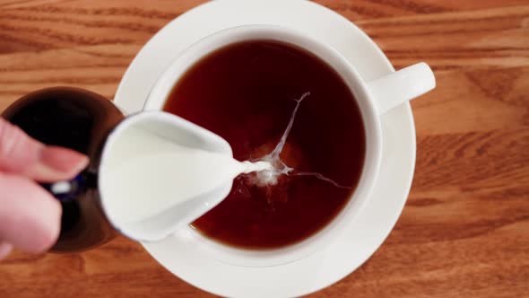 Pouring Milk Into Black Tea Top View