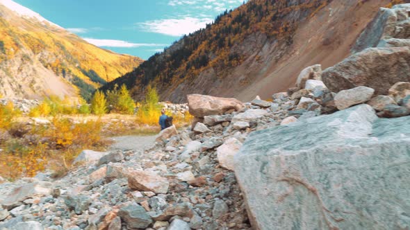 young tourist walks through mountainous area and looks at beautiful landscape.