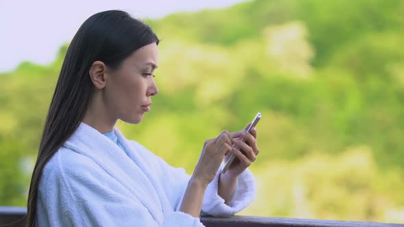 Young Woman Texting Message on Smartphone Standing Hotel Balcony Outdoors, Work