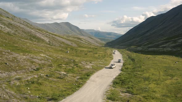 SUVs are Driving on a Dirt Road in the Valley of the Khibiny Mountains