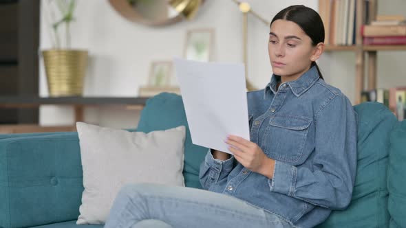 Professional Latin Woman Reading Documents at Work 