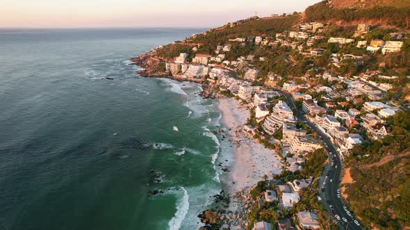 Clifton beachfront hotels overlooking turquoise ocean at sunset in Cape Town, aerial