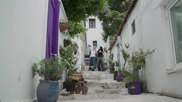 Two women walking down from a narrow street in Bozcaada Island Turkey