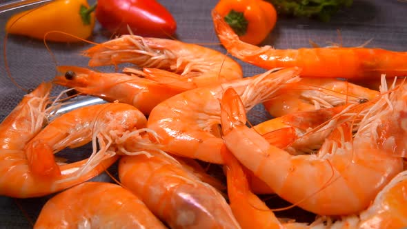 Closeup of the Hand Laying a Delicious Unpeeled Shrimp in a Glass Bowl