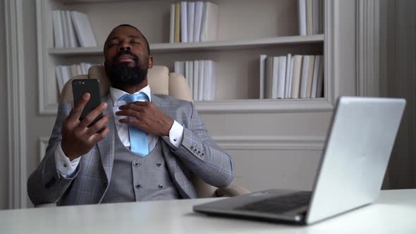 Happy Rich Man Is Resting in Room, Communicating with Friends or Family By Video Call in Cell Phone