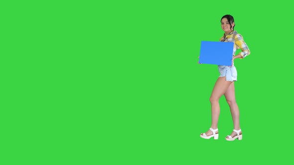 Young Charming Brunette Model Holding Empty Board on a Green Screen, Chroma Key.