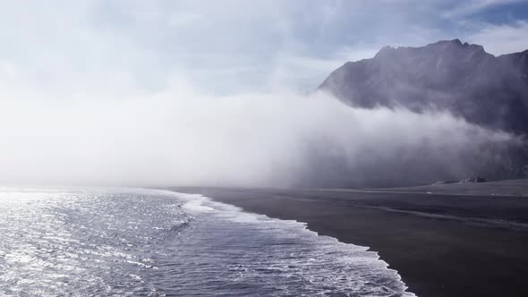 Drone Flight Of Surf And Black Coastline Under Mist